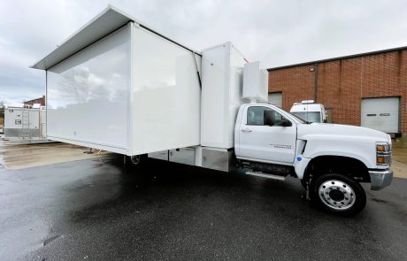 Expandable laboratory truck with extended side module creating additional workspace for mobile laboratory operations.