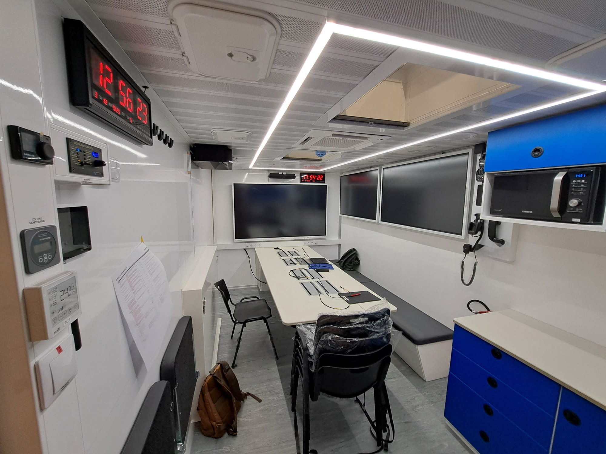 Interior of mobile command truck with integrated communication systems, operator desks and monitoring screens Interior of mobile command truck with integrated communication systems, operator desks and monitoring screens