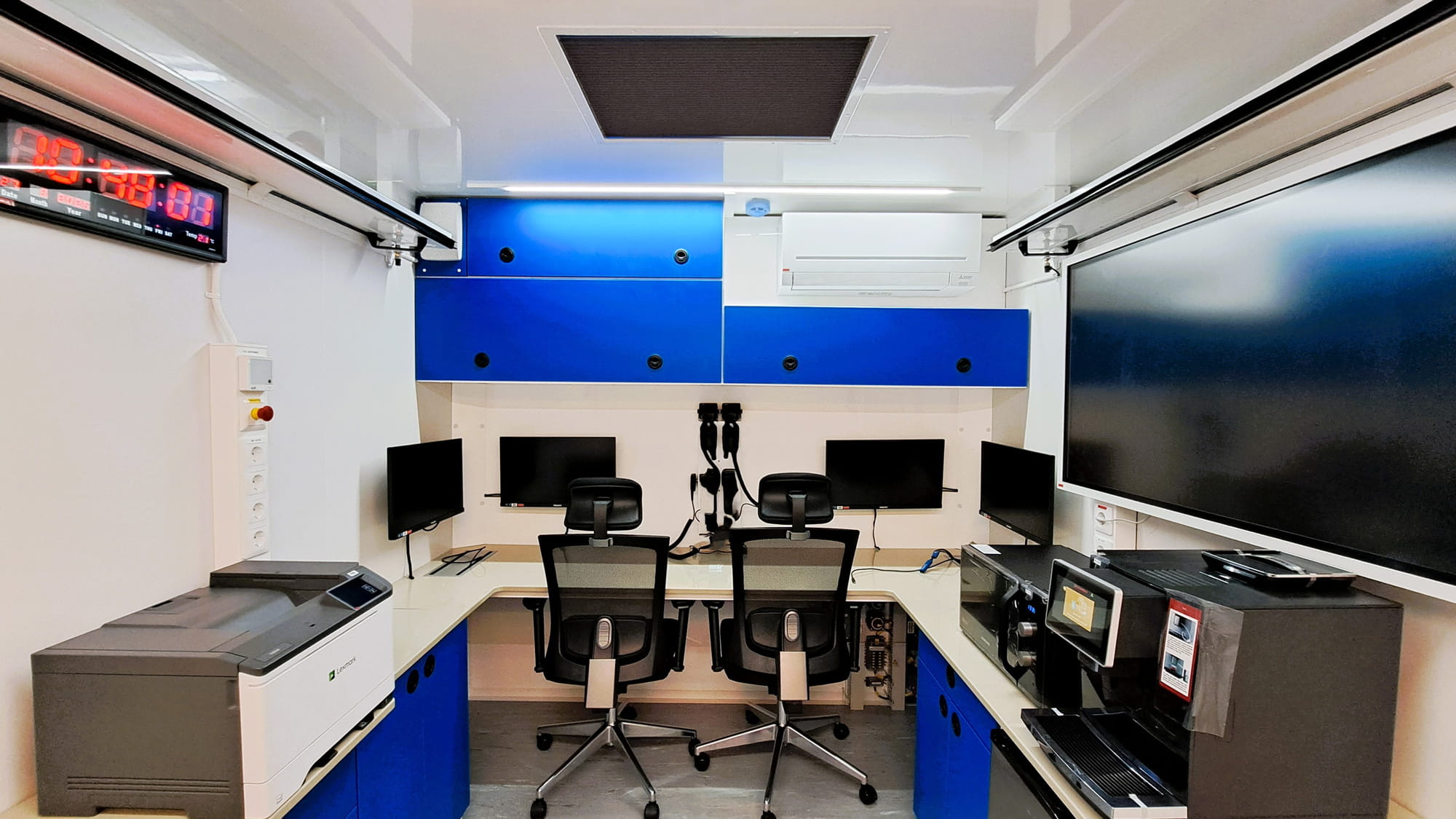 Communications room inside expandable command truck with radio, IT and control systems for field coordination Communications room inside expandable command truck with radio, IT and control systems for field coordination